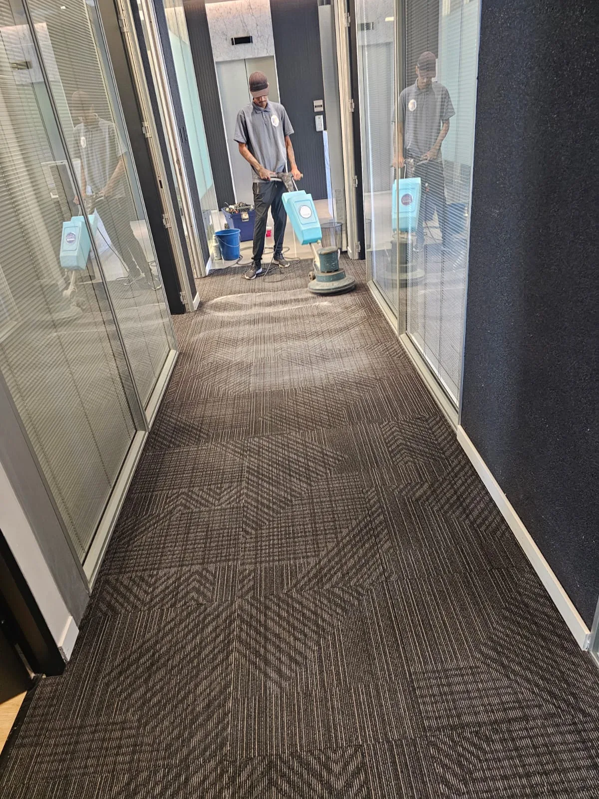 Equipe da Railimp realizando limpeza de carpete em corredor de escritório